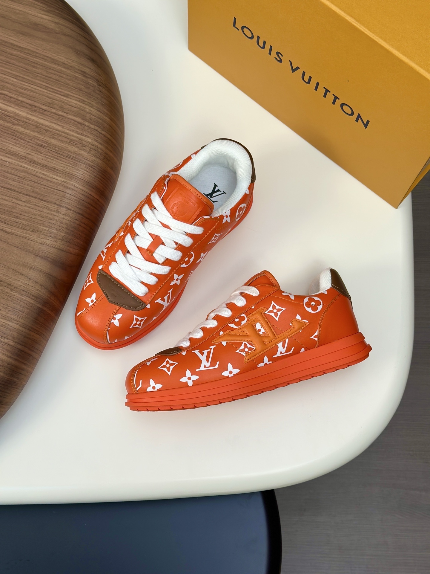 LV Buttersoft sneaker in orange monogram-printed lambskin and calf leather.  LV BUTTERSOFT