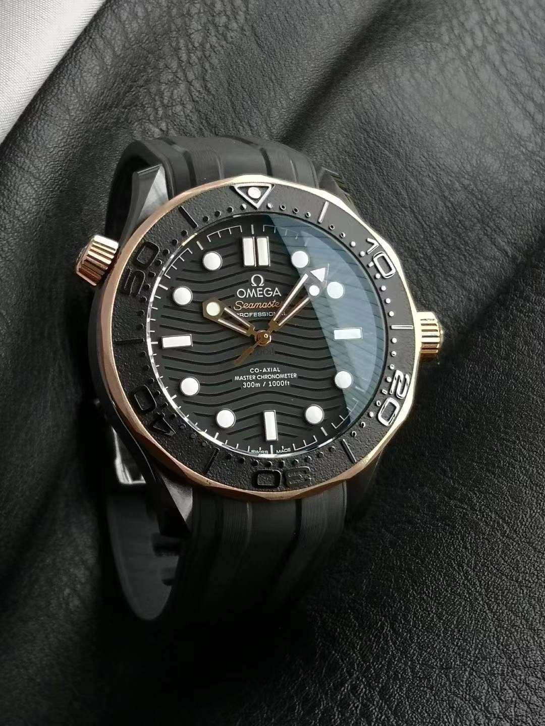 Omega Seamaster Diver 300M Co-Axial Master Chronometer with a black ceramic case, Sedna gold bezel, black dial, and a black rubber strap