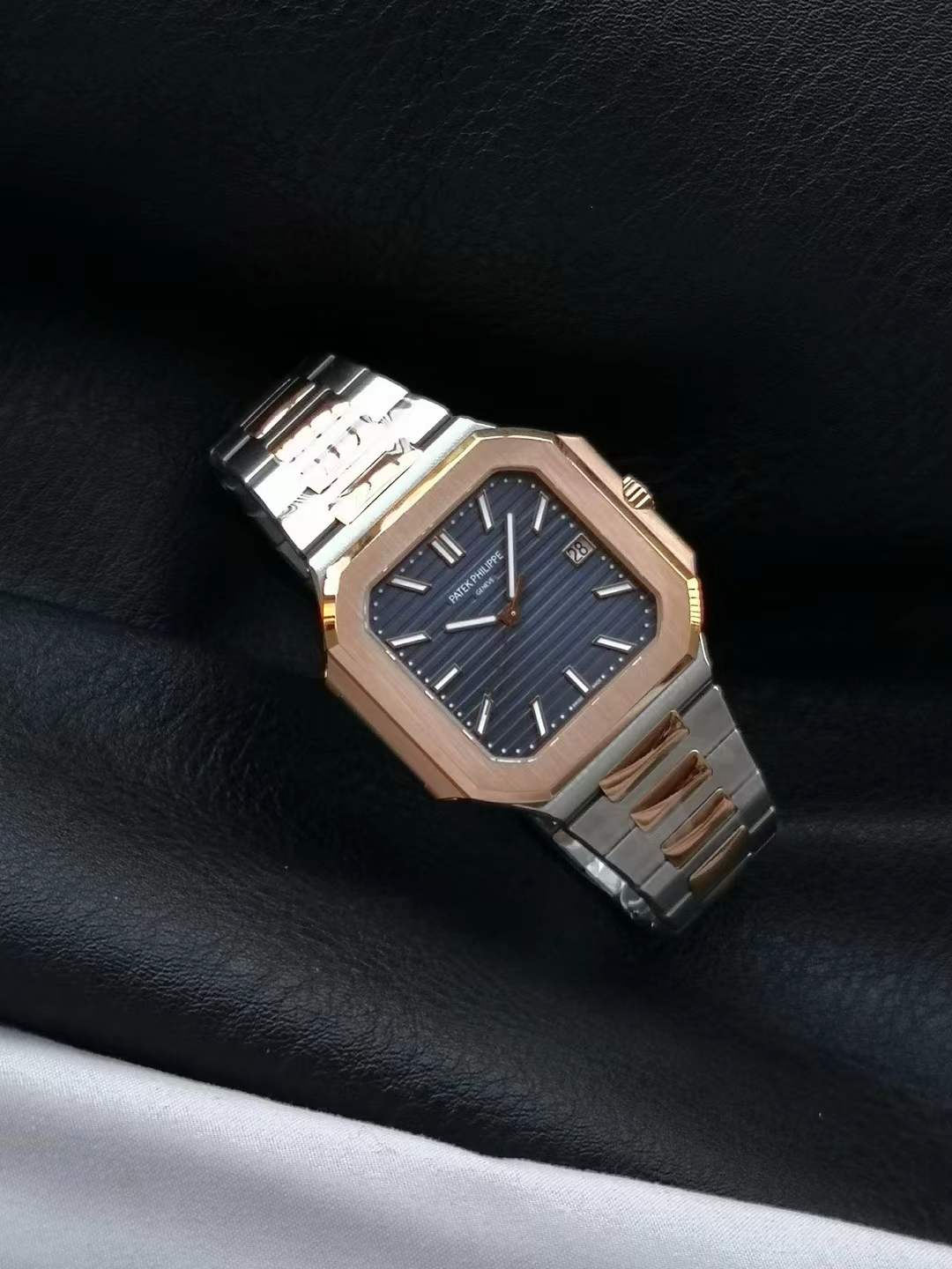 Patek Philippe Cubitus two-tone model, reference 5821/1AR-001, featuring a steel case and side links, a rose gold central links bracelet and bezel, and a sunburst blue dial