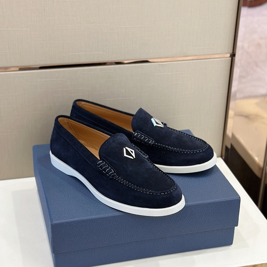 Dior navy blue suede loafers with white soles and a diamond-shaped emblem
