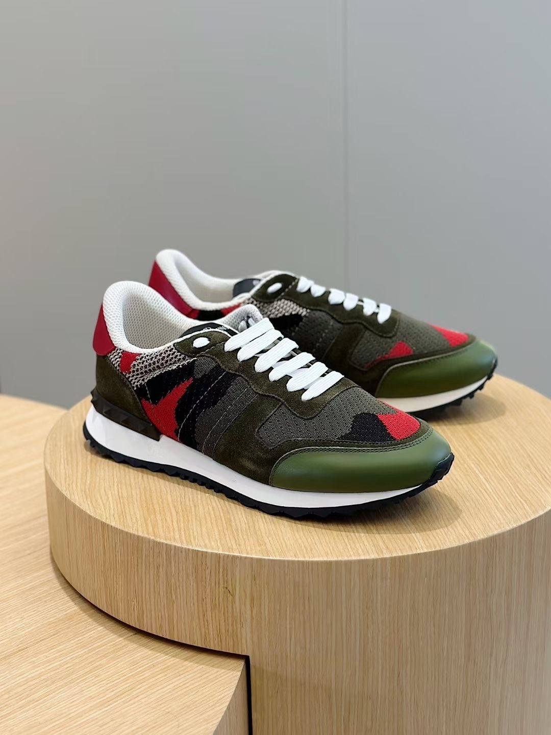 Valentino Garavani Camouflage Rockrunner sneakers in green and black calf leather with signature rubberized pyramid studs at the heel counter.    Would you like to know more