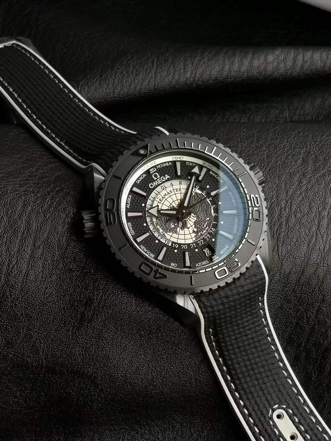 Omega Seamaster Planet Ocean 600M Co-Axial Master Chronometer Worldtimer watch with a black ceramic case and a black and grey rubber strap