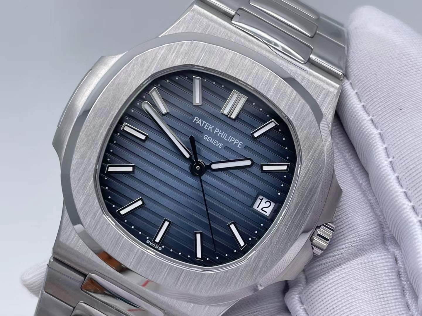 Patek Philippe Nautilus watch with a blue sunburst horizontally embossed dial and stainless steel case and bracelet