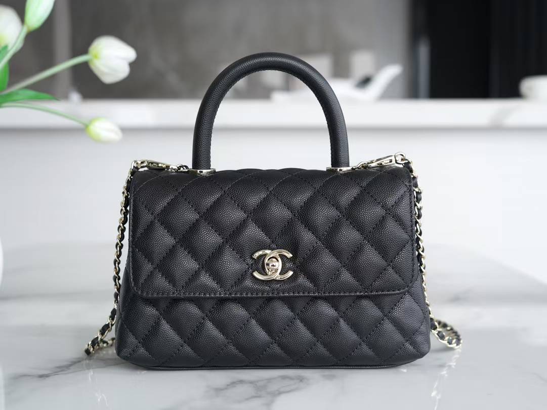 Chanel Small Coco Handle flap bag in black quilted caviar leather with a lizard top handle and light gold hardware