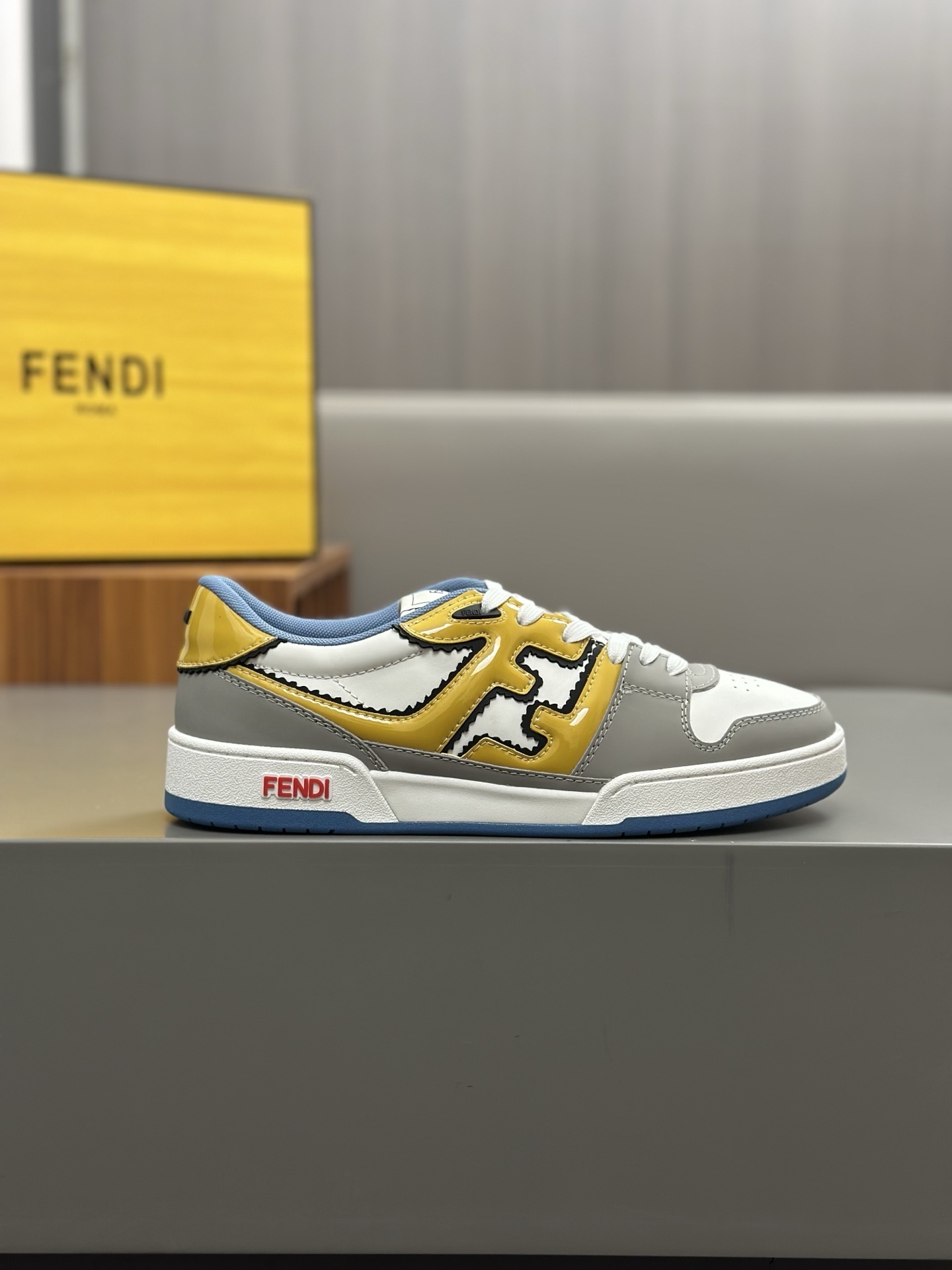Fendi Match sneakers in a grey, white, and yellow colour-block design with the FF motif on the sidewalls