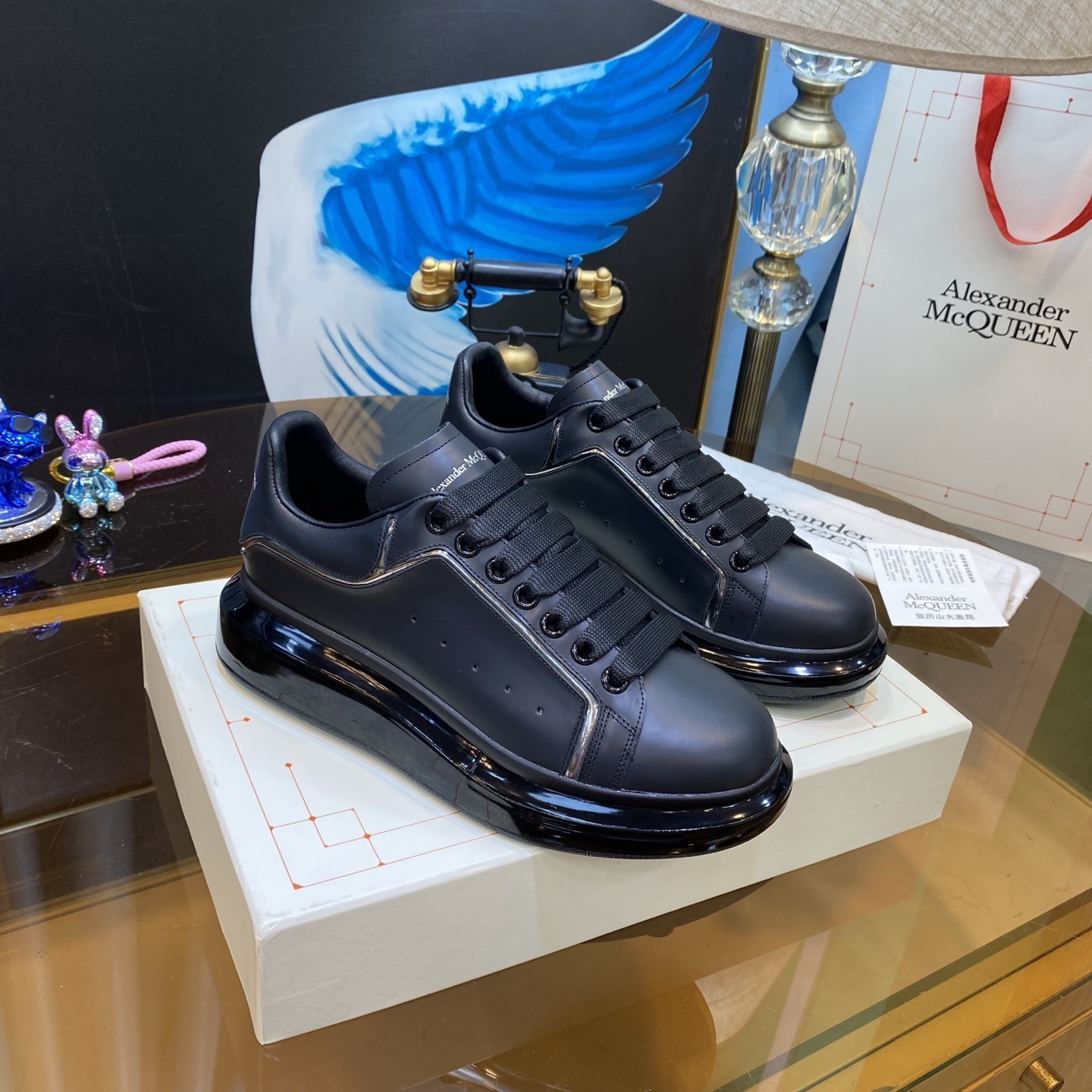 Alexander McQueen Men's Oversized Transparent Sole Sneakers in black calf leather with a glossy black oversized rubber sole
