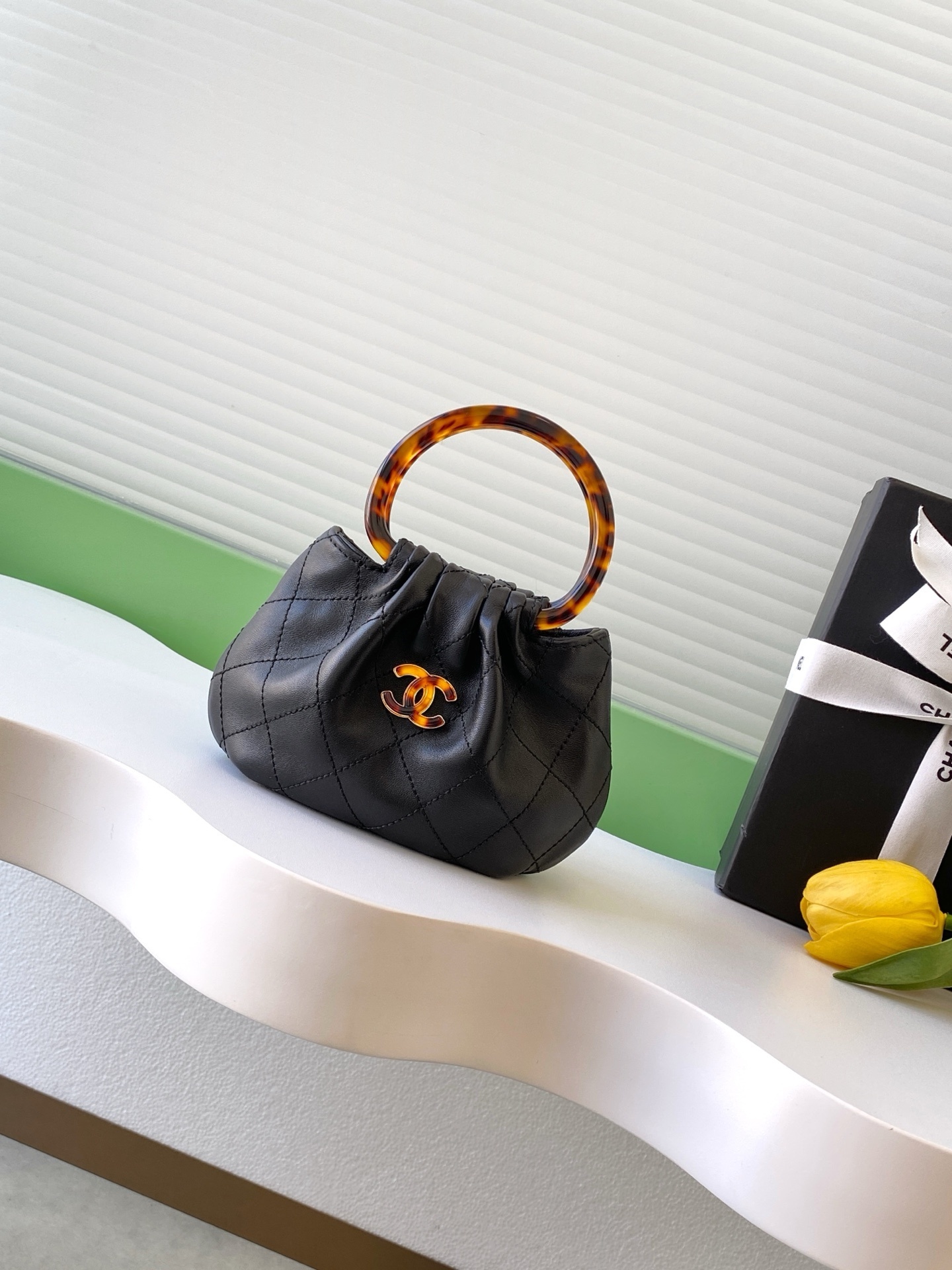 Chanel small hobo bag with a black leather body and a tortoise-shell handle