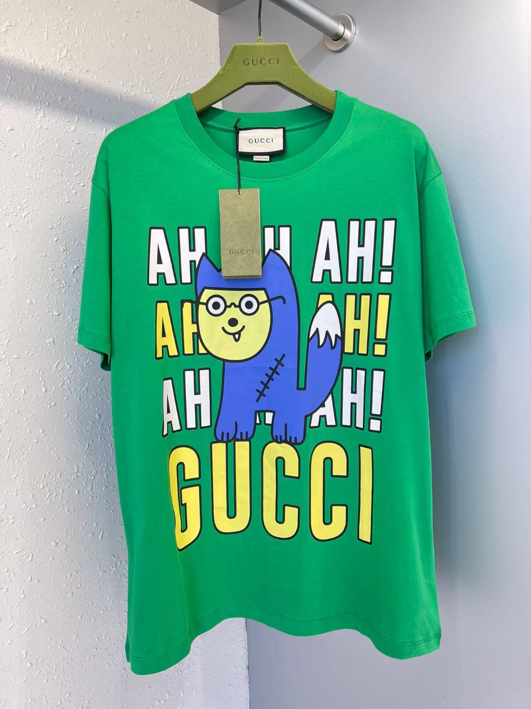 Green Gucci t-shirt with a cartoon character graphic and "AH AH! AHH! GUCCI" text