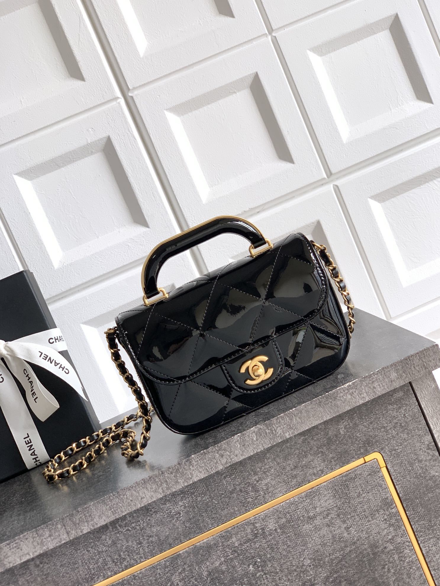 Chanel Mini Flap Bag with Top Handle in black high-shine calfskin and gold-tone metal.