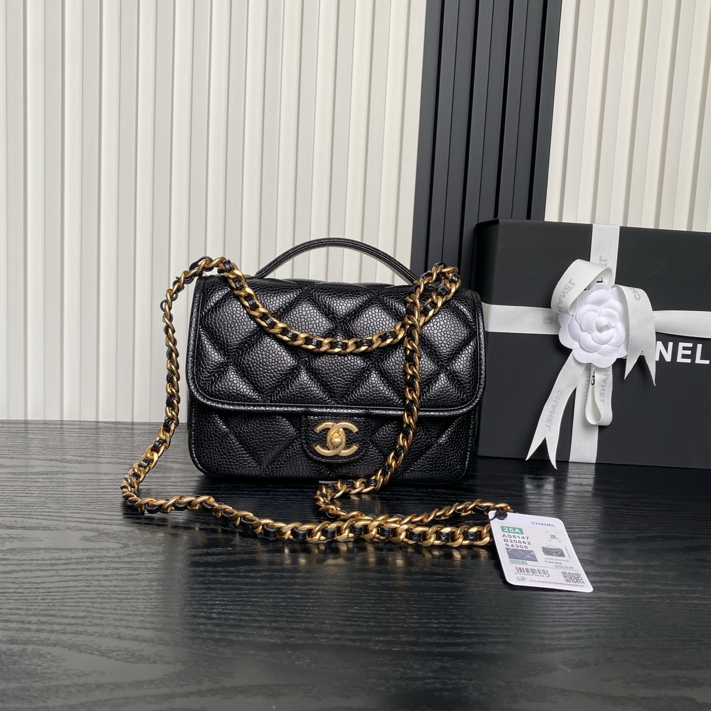 Chanel Flap bag with a top handle in black quilted leather with gold-tone hardware