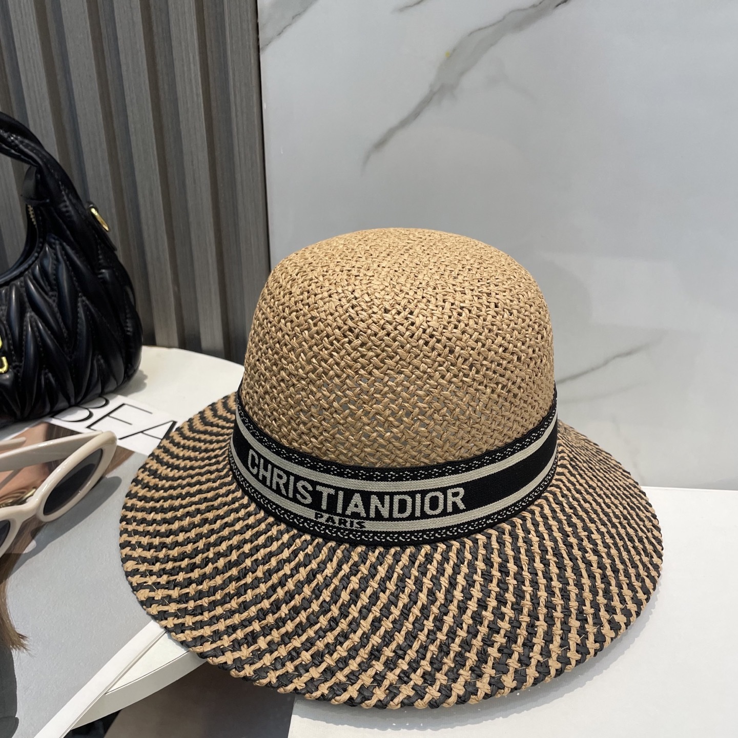 Christian Dior D-Bobby large brim hat in beige and black straw with a "Christian Dior Paris" signature band