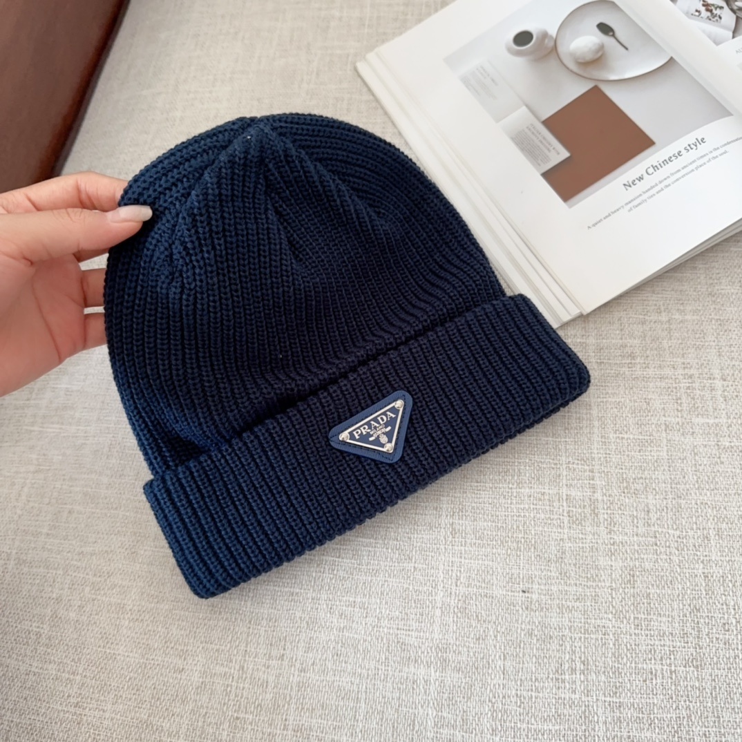 Prada triangle-logo ribbed knit wool and cashmere-blend beanie in a dark blue color