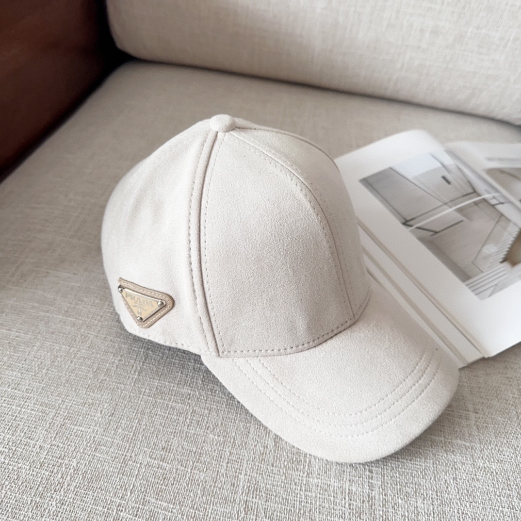 Prada Re-Nylon baseball cap in a beige or off-white color with the iconic enamel triangle logo