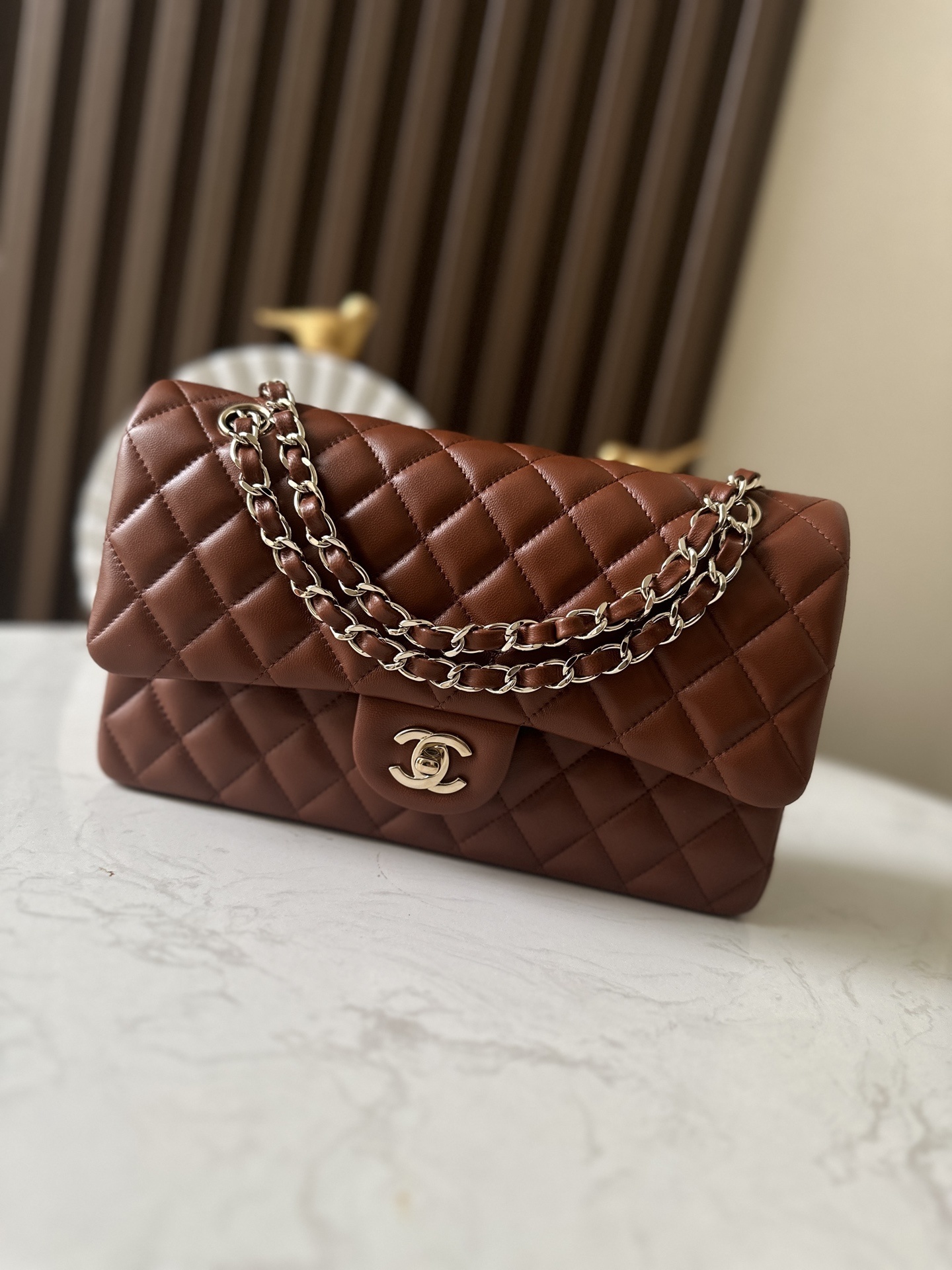 Chanel Classic Double Flap bag in a caramel or burgundy quilted lambskin leather with silver-tone hardware
