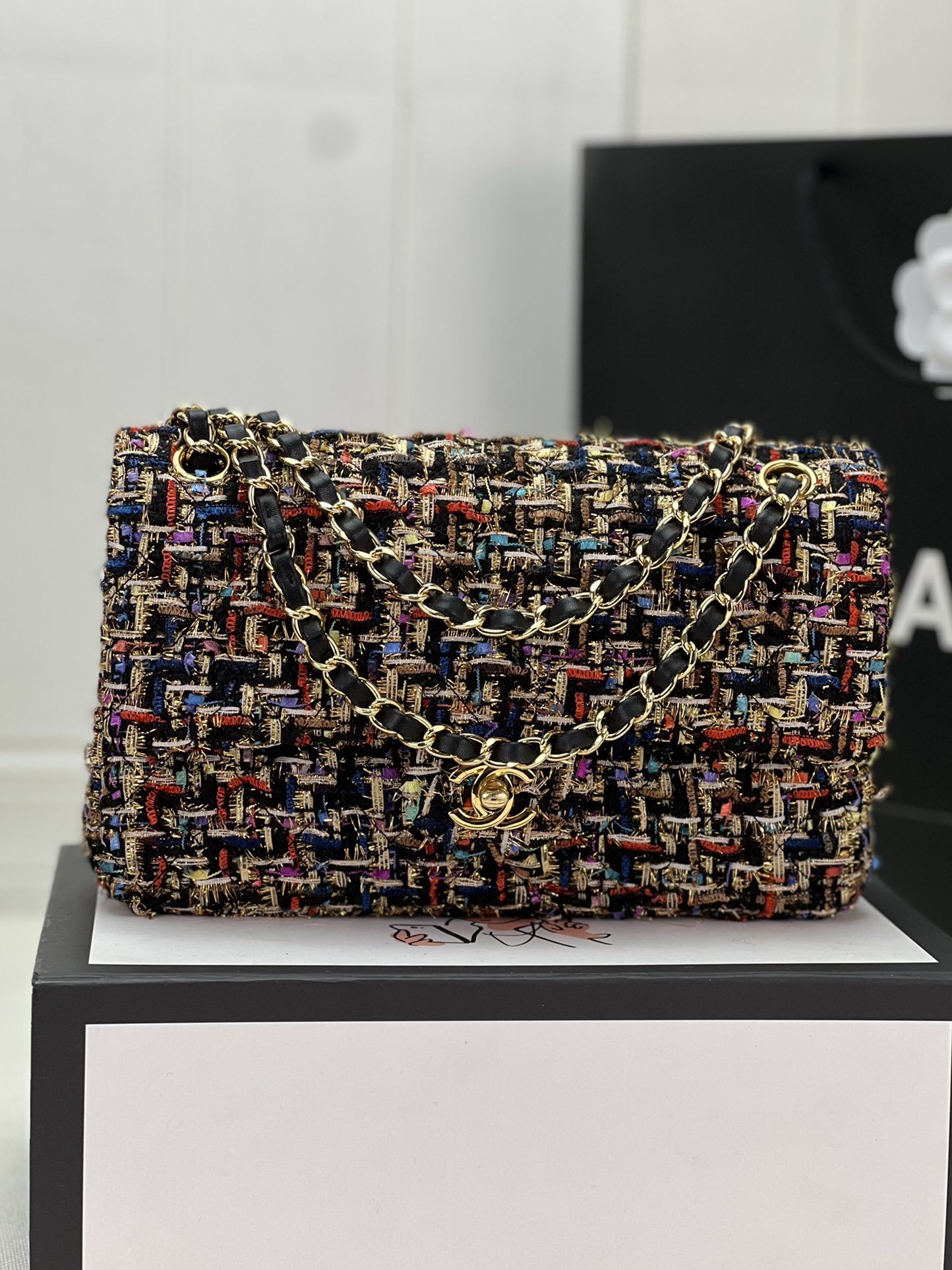 Chanel tweed shoulder bag with a signature interlocking CC logo turn-lock closure and gold-tone chain and leather strap