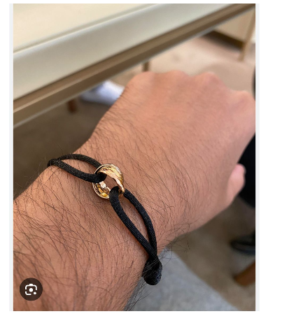 Cartier Trinity cord bracelet  18k white, yellow, and rose gold rings on an adjustable black cord