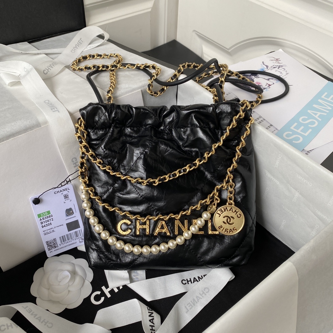 Chanel 22 Mini Handbag made of black shiny calfskin with gold-tone metal hardware and a pearl chain strap