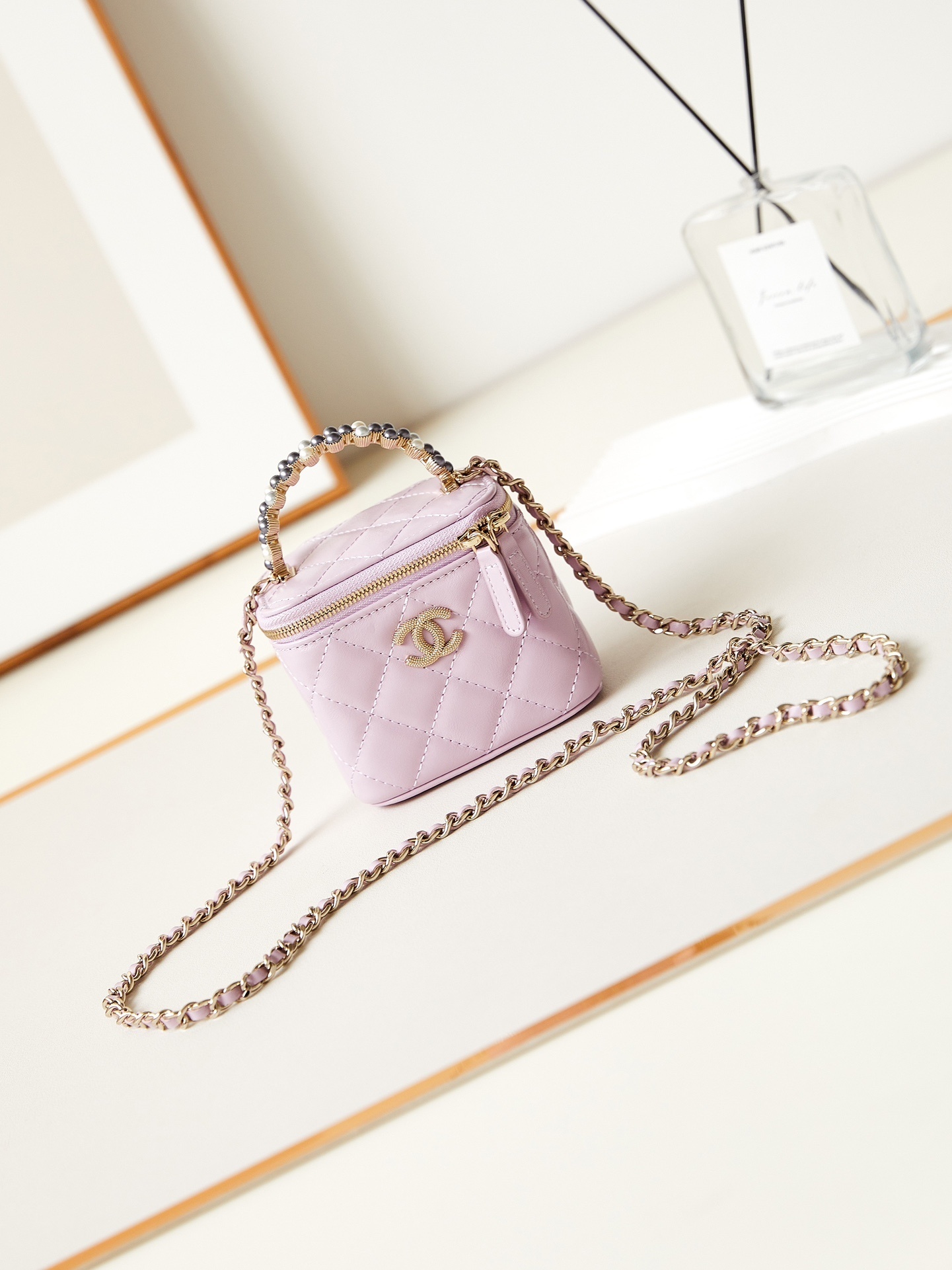 Chanel Mini Vanity bag in a light purple or pink hue with gold-tone hardware