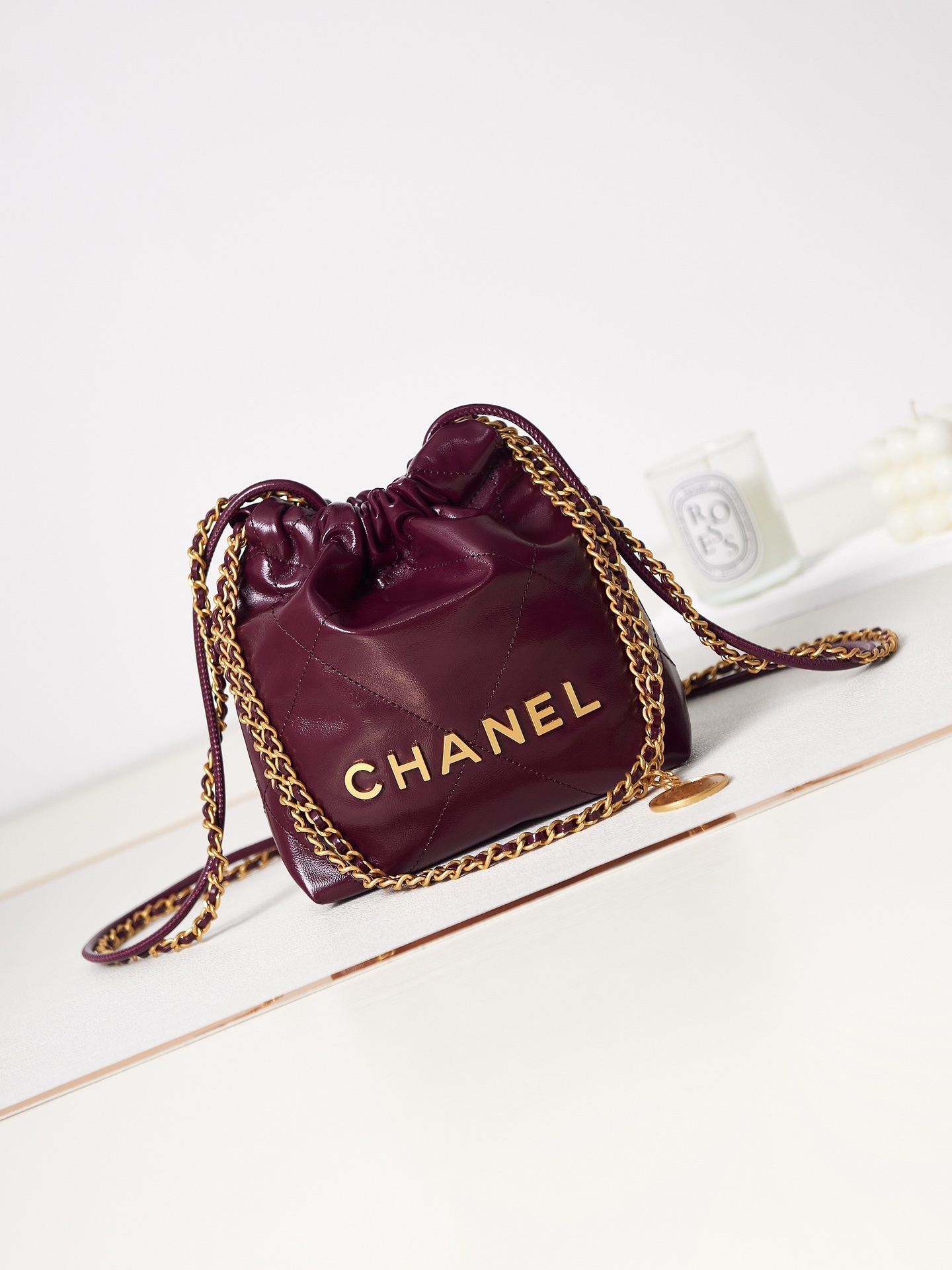 Chanel 22 small handbag in shiny calfskin with gold-tone metal hardware.