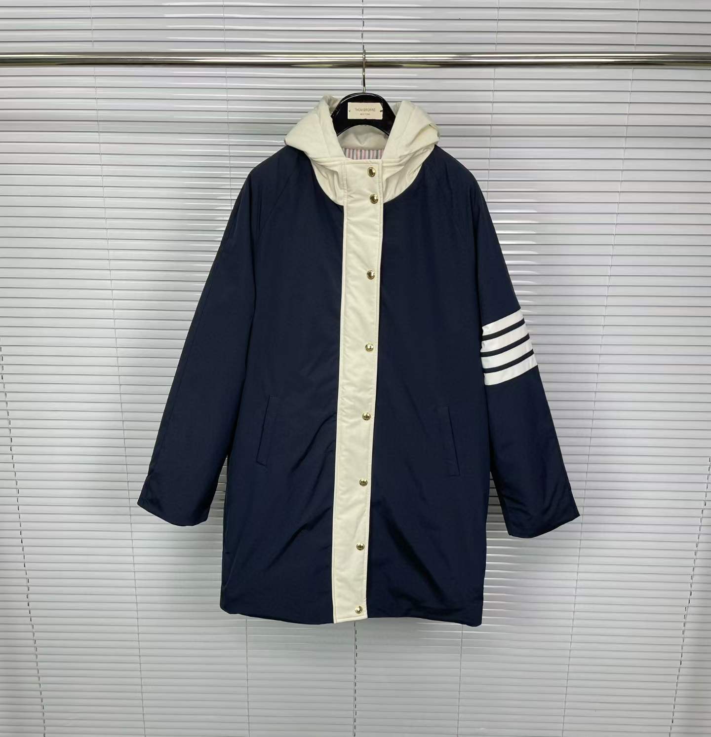 Thom Browne 4-Bar Football Sideline Parka coat in navy blue with a removable white hood and down-feather filling.