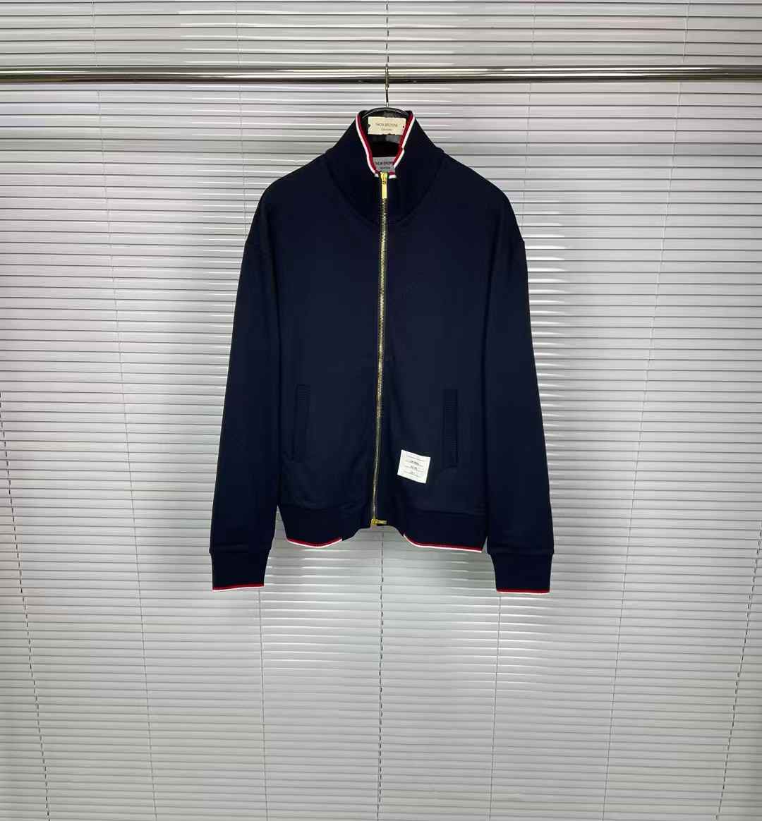 Thom Browne navy blue bomber jacket with a front zip closure tricolor and a logo patch