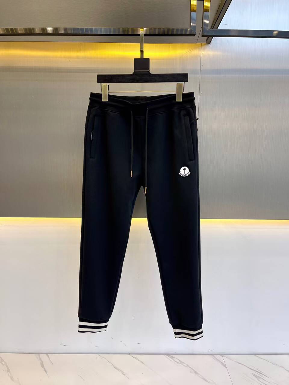 Moncler sweat pants with a logo patch and striped cuffs