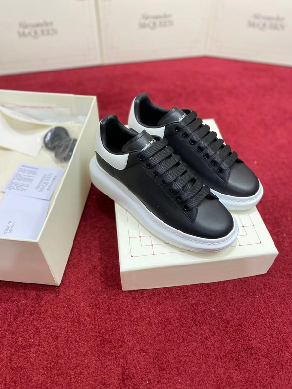 Alexander McQueen Oversized Sneaker in black calf leather with a white heel detail and oversized white rubber sole