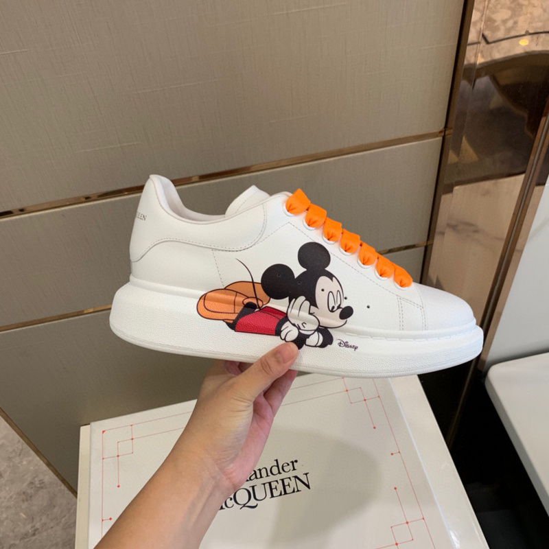 Alexander McQueen Oversized sneakers with a Disney Mickey Mouse graphic and orange laces.