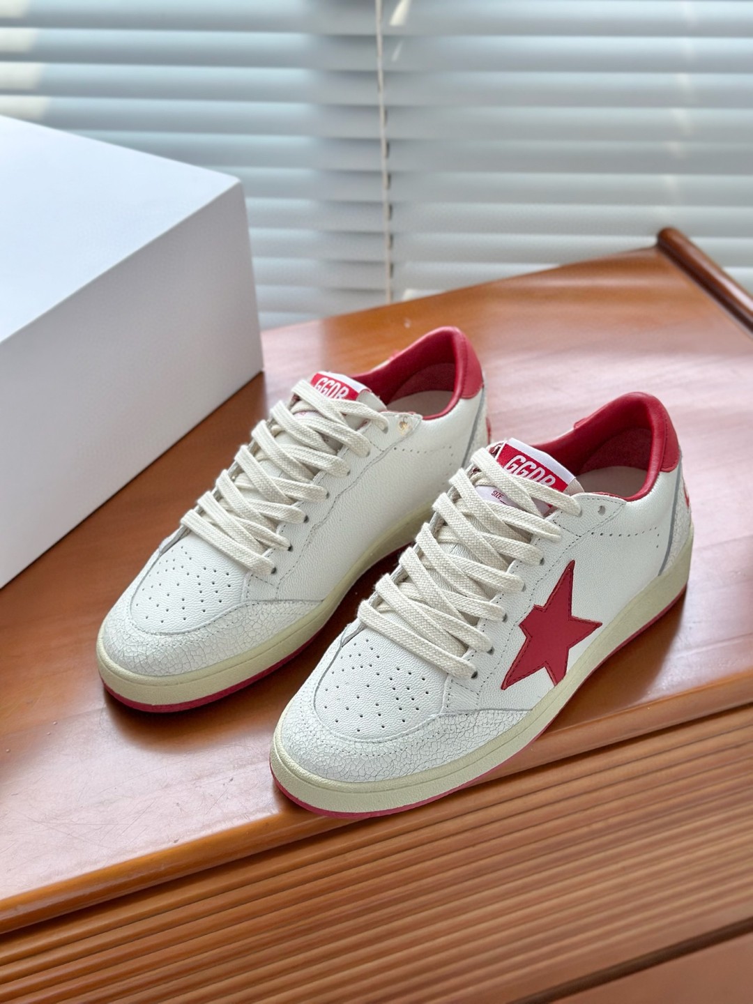 Golden Goose Ball Star low-top sneakers in white leather with a red star and heel tab.