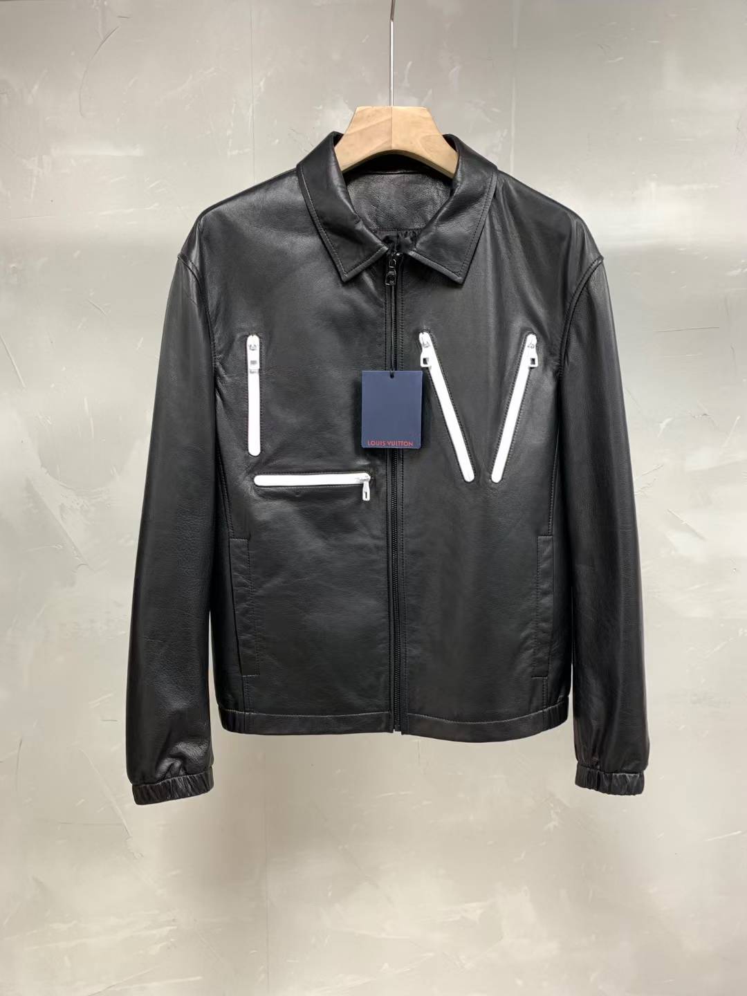 LV black leather jacket with white 'LV' inserts.