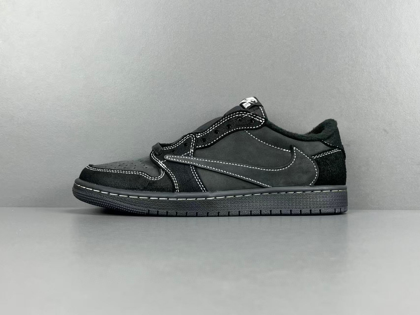 Nike Air Jordan 1 Low OG SP x Travis Scott "Black Phantom" sneaker with a black nubuck and suede upper and white contrast stitching.