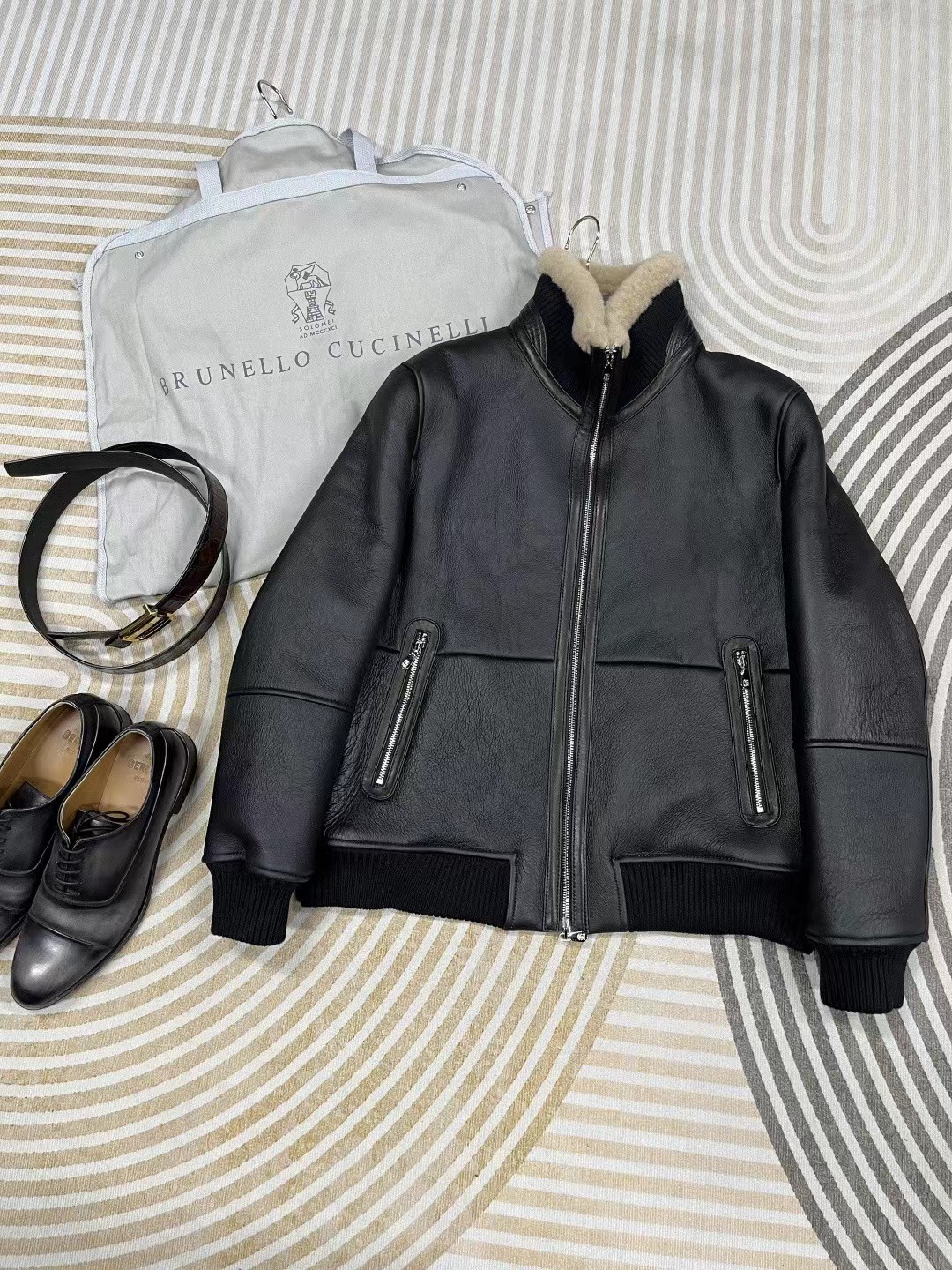 Brunello Cucinelli black shearling bomber jacket possibly a Belstaff Trace jacket.