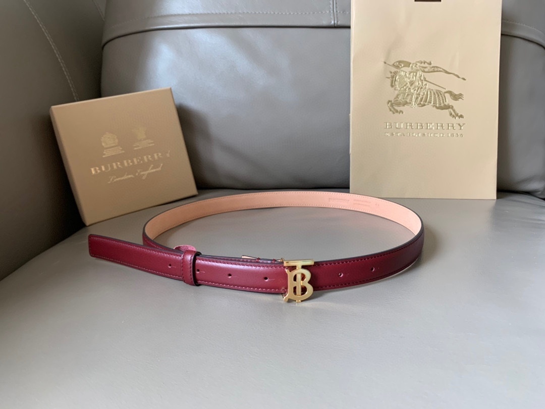 Burberry leather belt in a burgundy or red color with a gold-plated