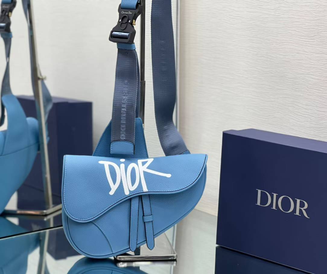 Dior and Shawn Saddle Bag in blue grained calfskin leather with a white logo print