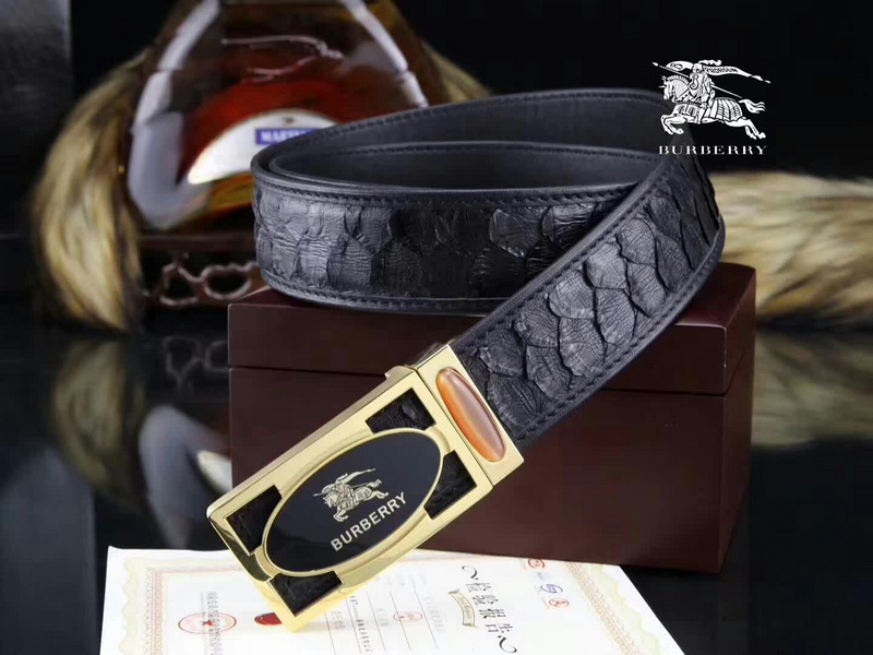 Burberry black belt with a gold-tone buckle and an embossed, possibly python or snakeskin, pattern finish.