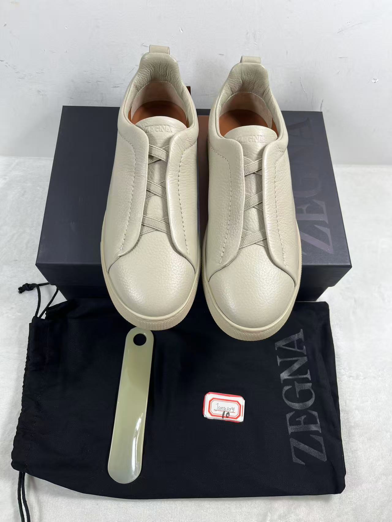 Zegna Triple Stitch leather low-top slip-on sneakers in an off-white or beige color