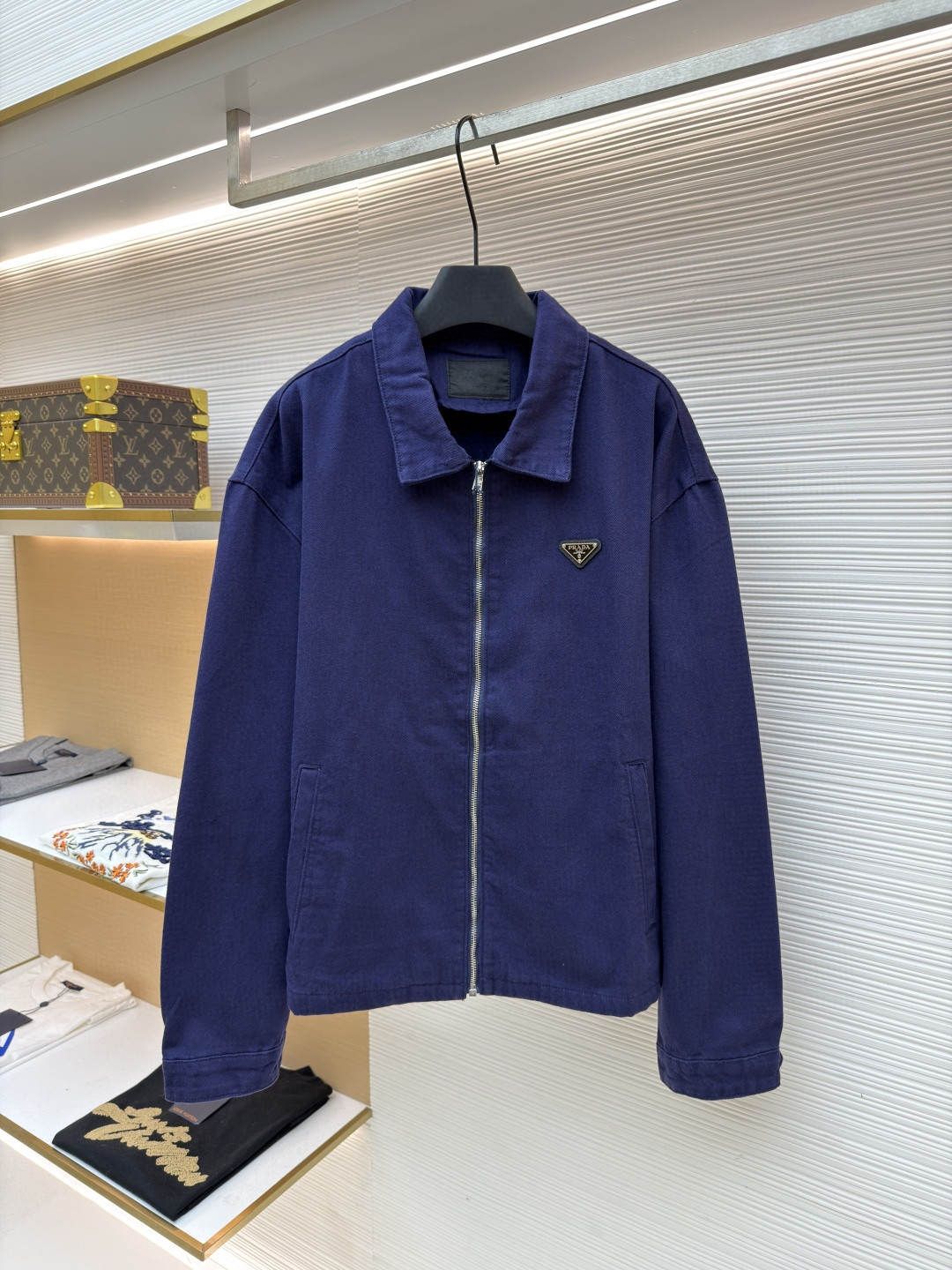 Prada blue organic cotton denim jacket with a classic collar, drop shoulder, long sleeves, and front zip fastening