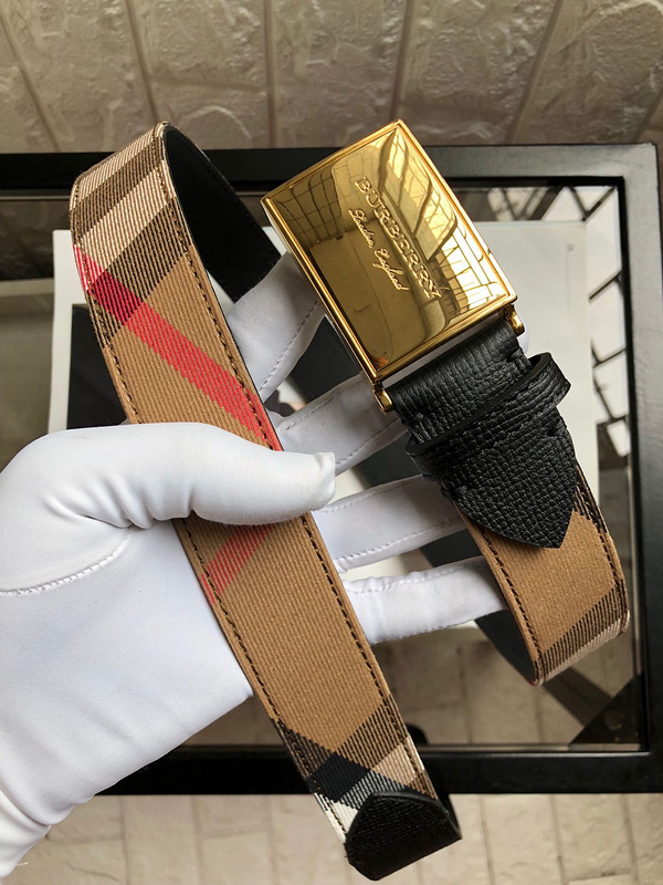 Burberry reversible belt in the signature Haymarket or Vintage check canvas and black leather with gold-tone hardware.