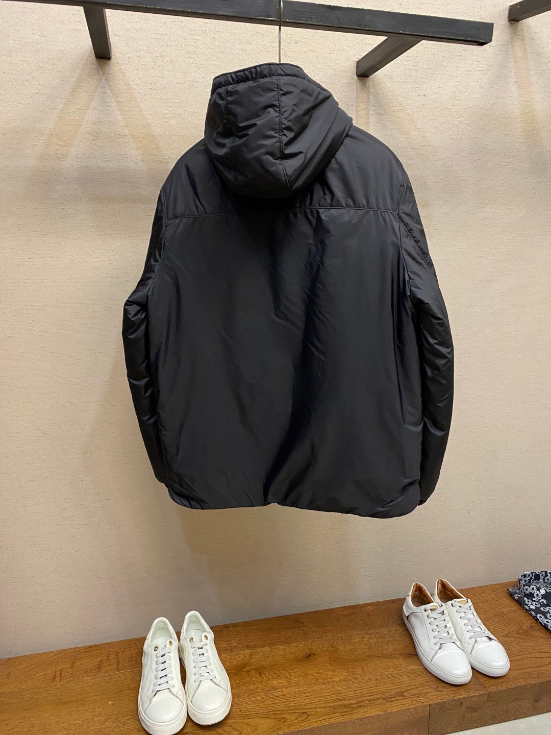 Prada Re-Nylon puffer jacket in navy blue and Black with a hood and triangle logo.