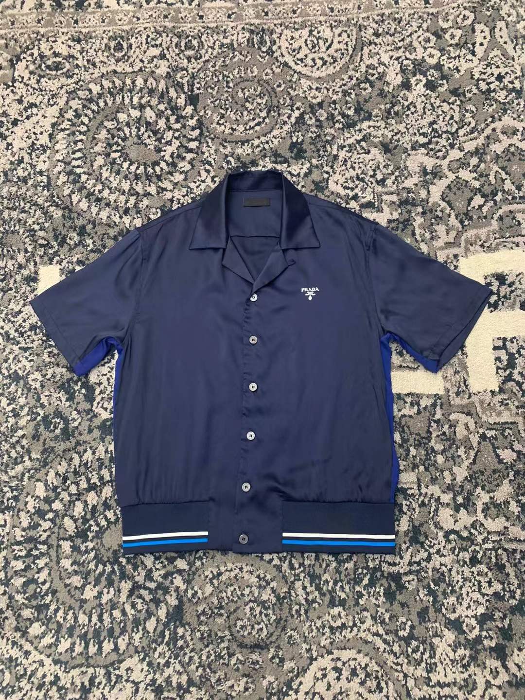 Prada Re-Nylon oversized triangle bowling shirt navy blue with a revere collar and elasticated striped hem.