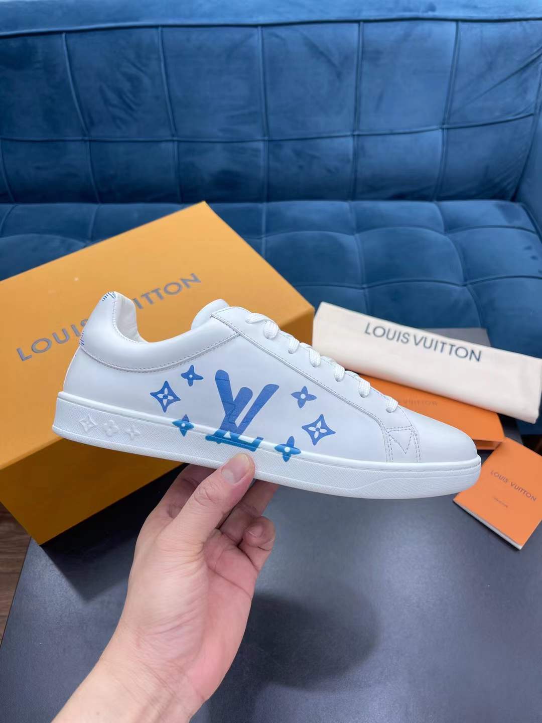 Lv Luxembourg Samothrace sneakers in white calf leather with blue monogram accents.