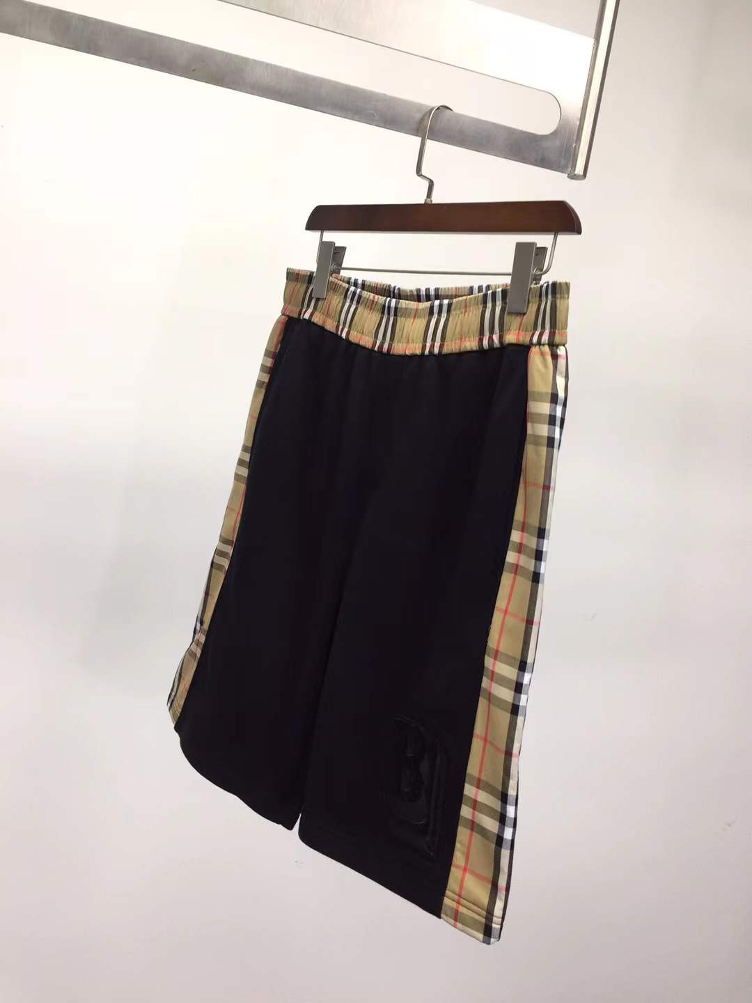 Burberry Kids 'Nolen' black cotton shorts with vintage check side panels and an embroidered logo.