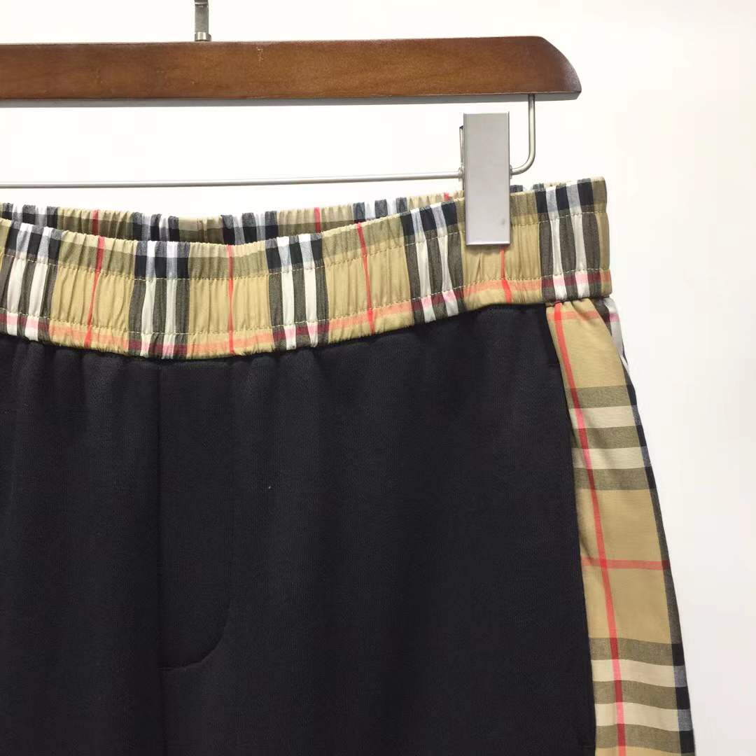 Burberry Kids 'Nolen' black cotton shorts with vintage check side panels and an embroidered logo.