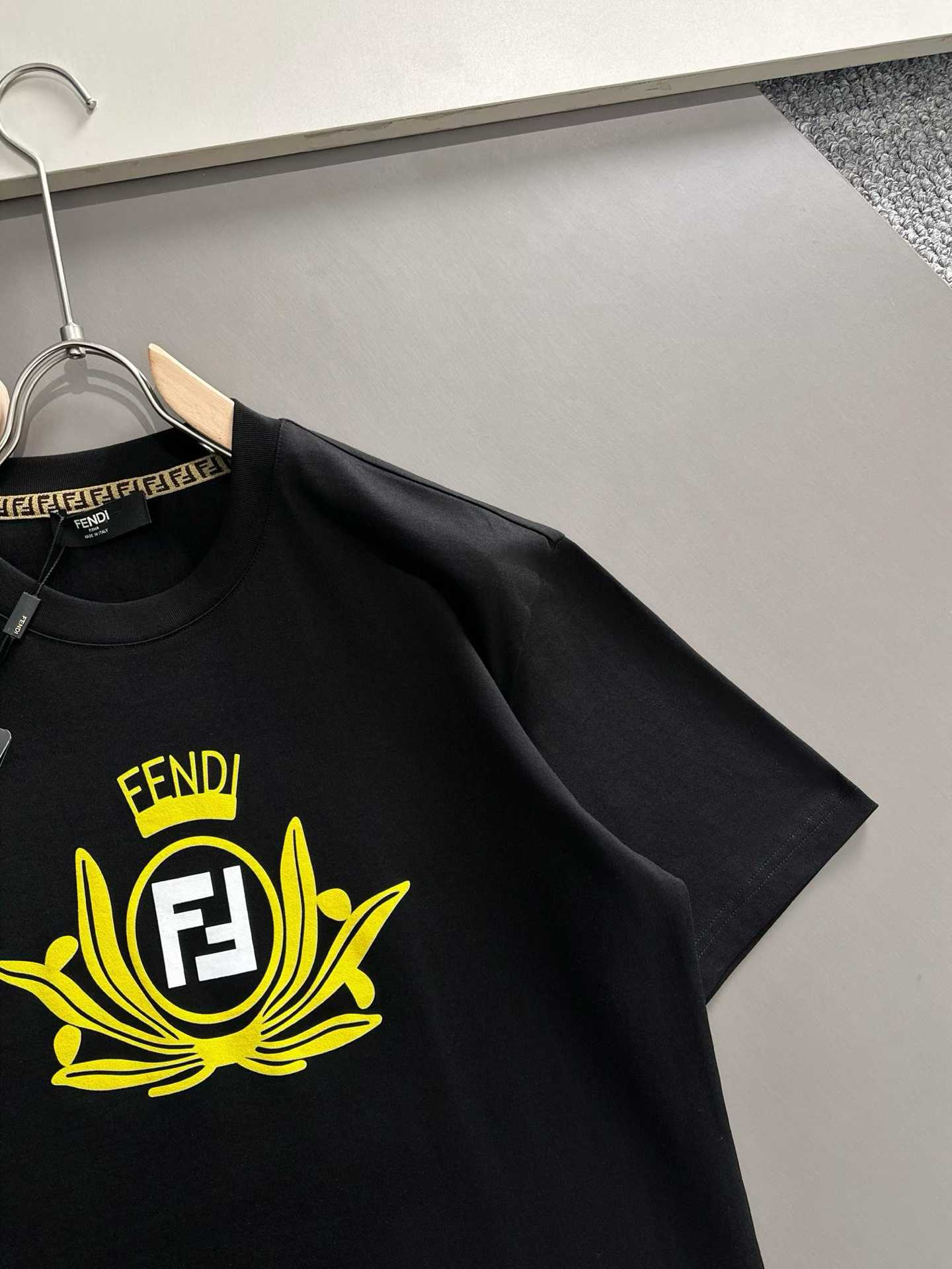 Fendi crew-neck T-shirt in black cotton featuring a yellow graphic crest and the signature FF logo