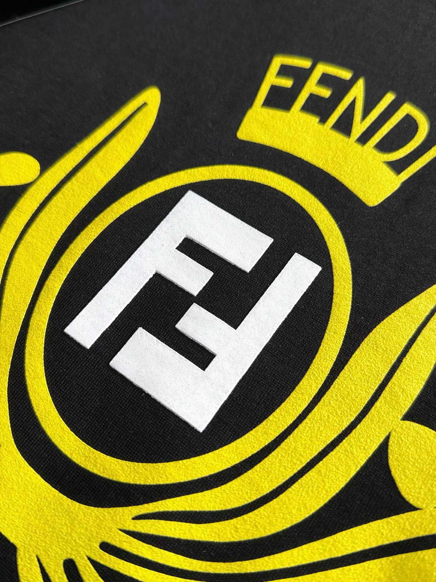 Fendi crew-neck T-shirt in black cotton featuring a yellow graphic crest and the signature FF logo