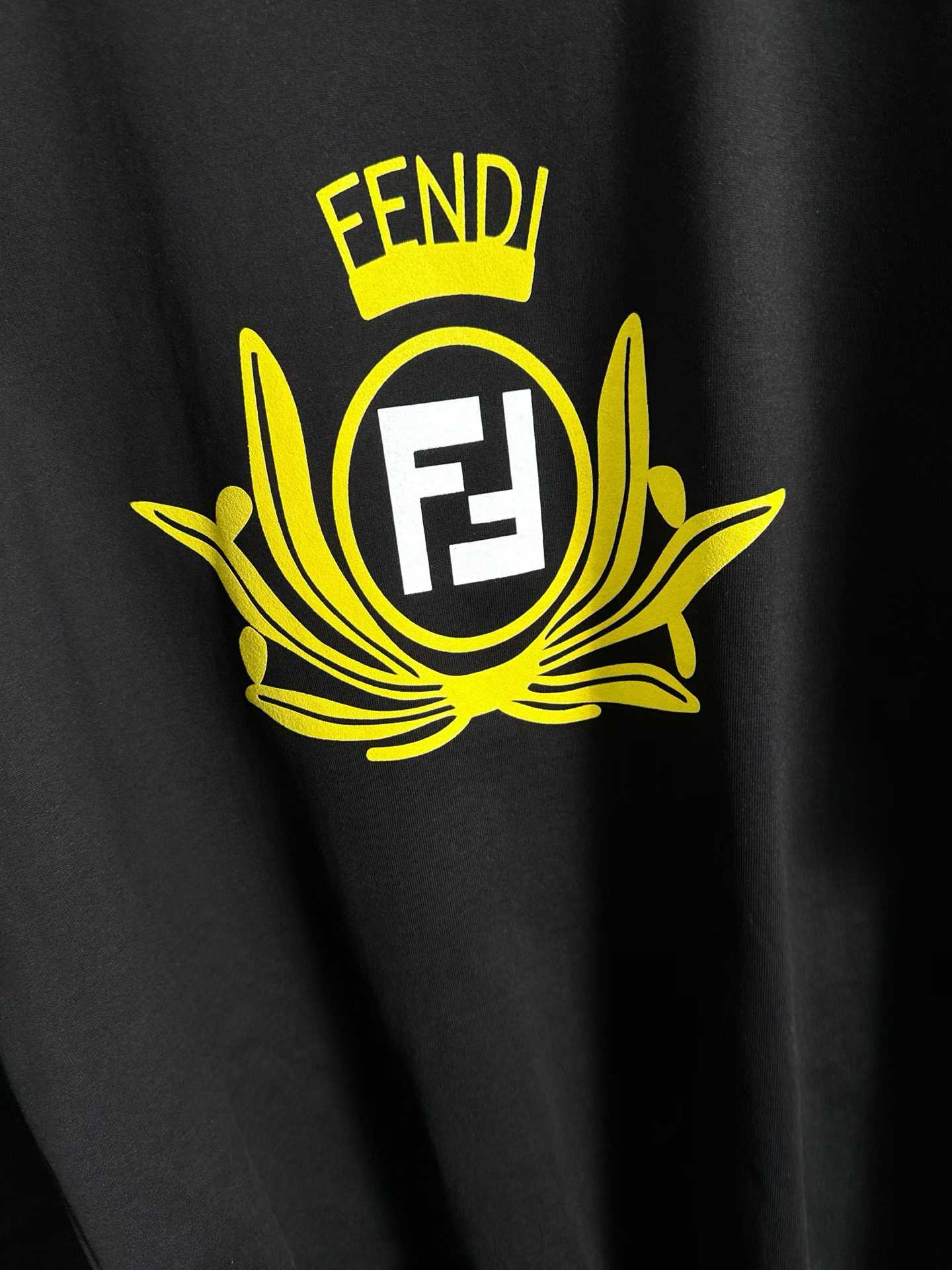Fendi crew-neck T-shirt in black cotton featuring a yellow graphic crest and the signature FF logo