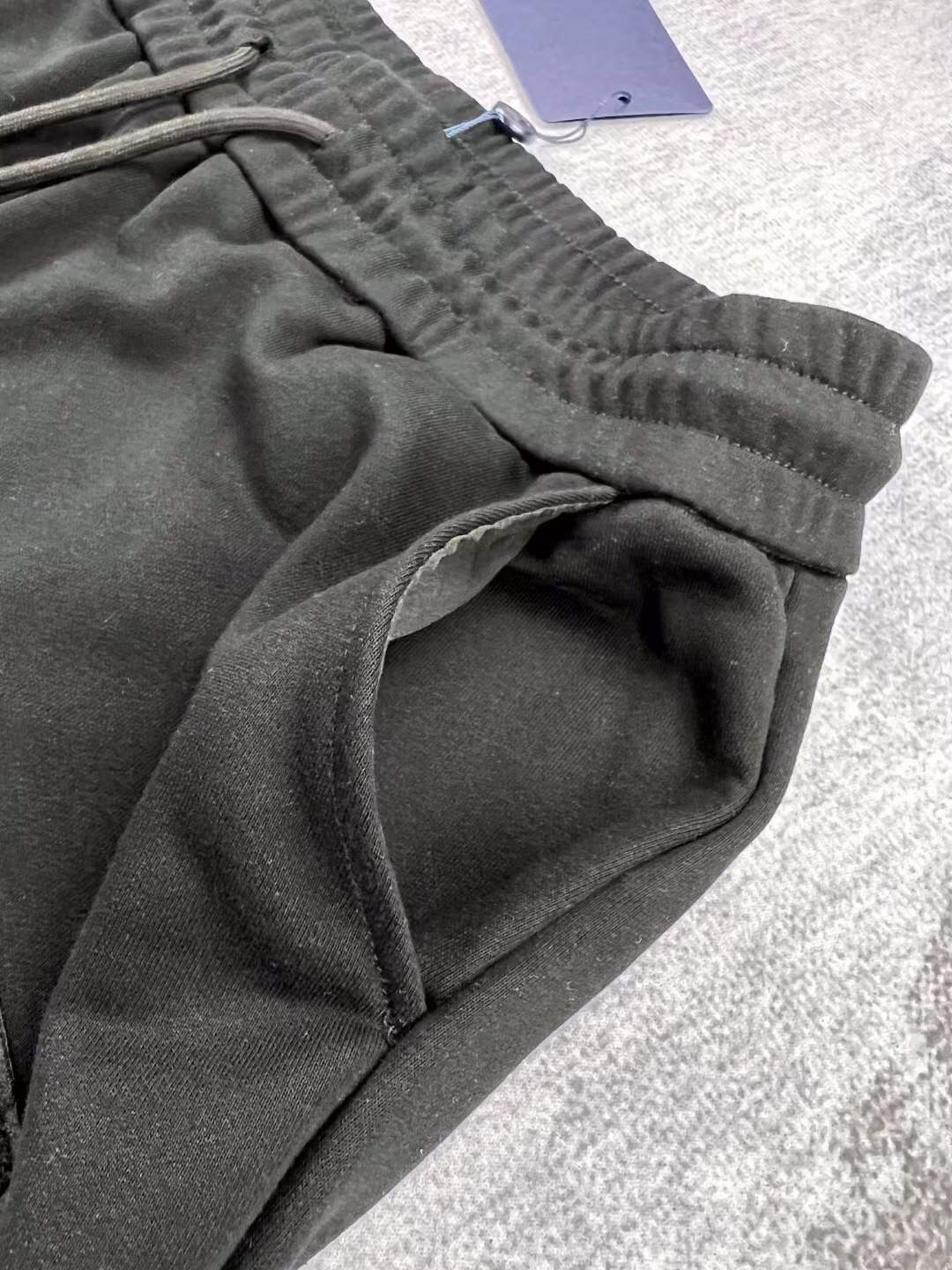 LV black shorts with green and yellow embroidered "L" and "V" patches