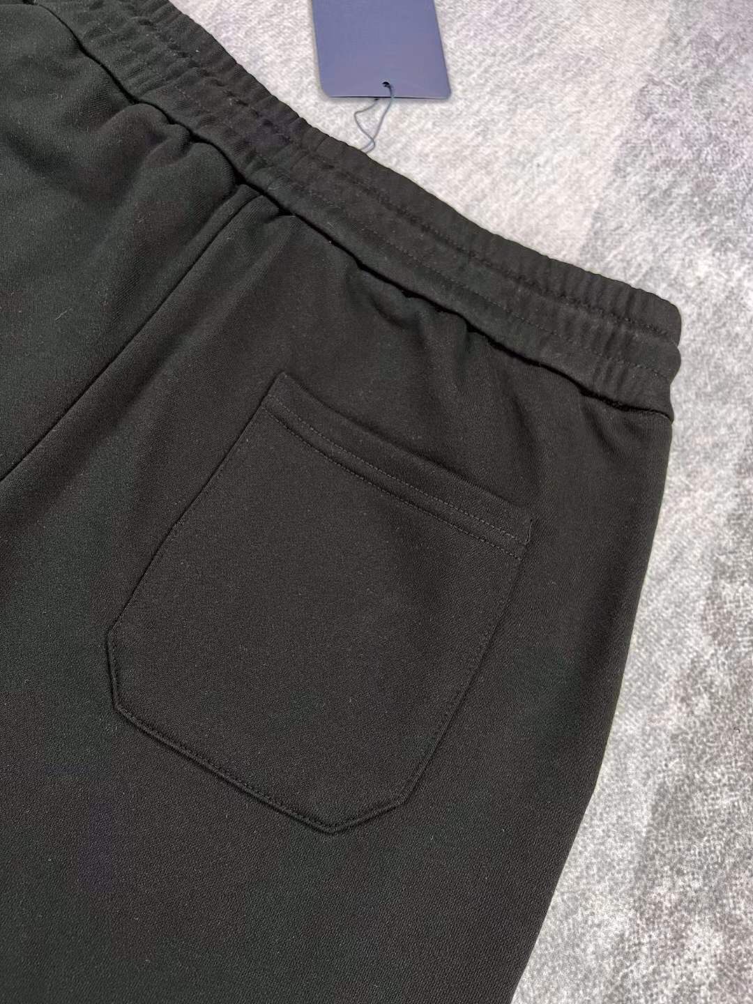 LV black shorts with green and yellow embroidered "L" and "V" patches