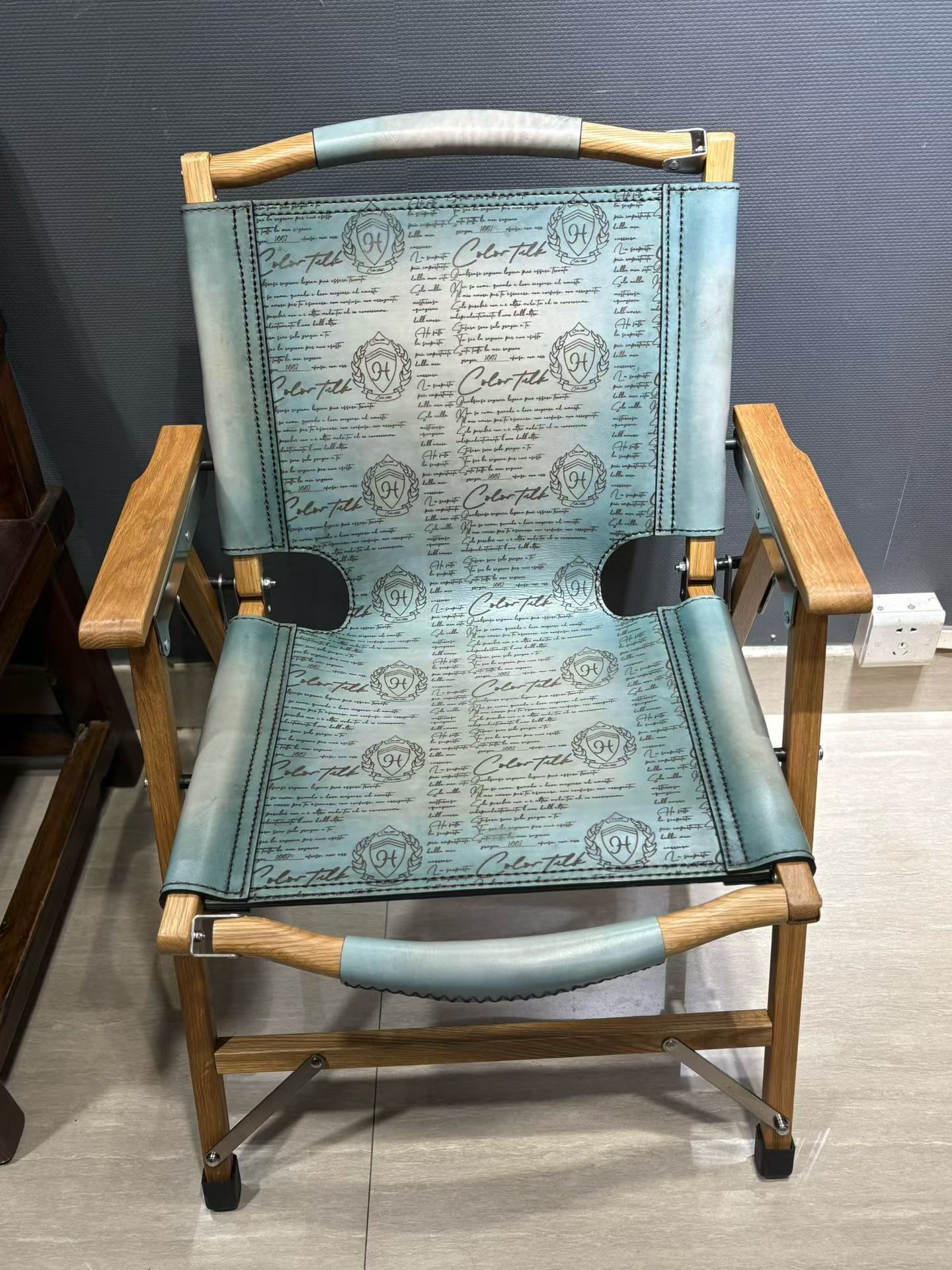 Berluti Metro wooden folding chair with a brown leather seat and backrest.
