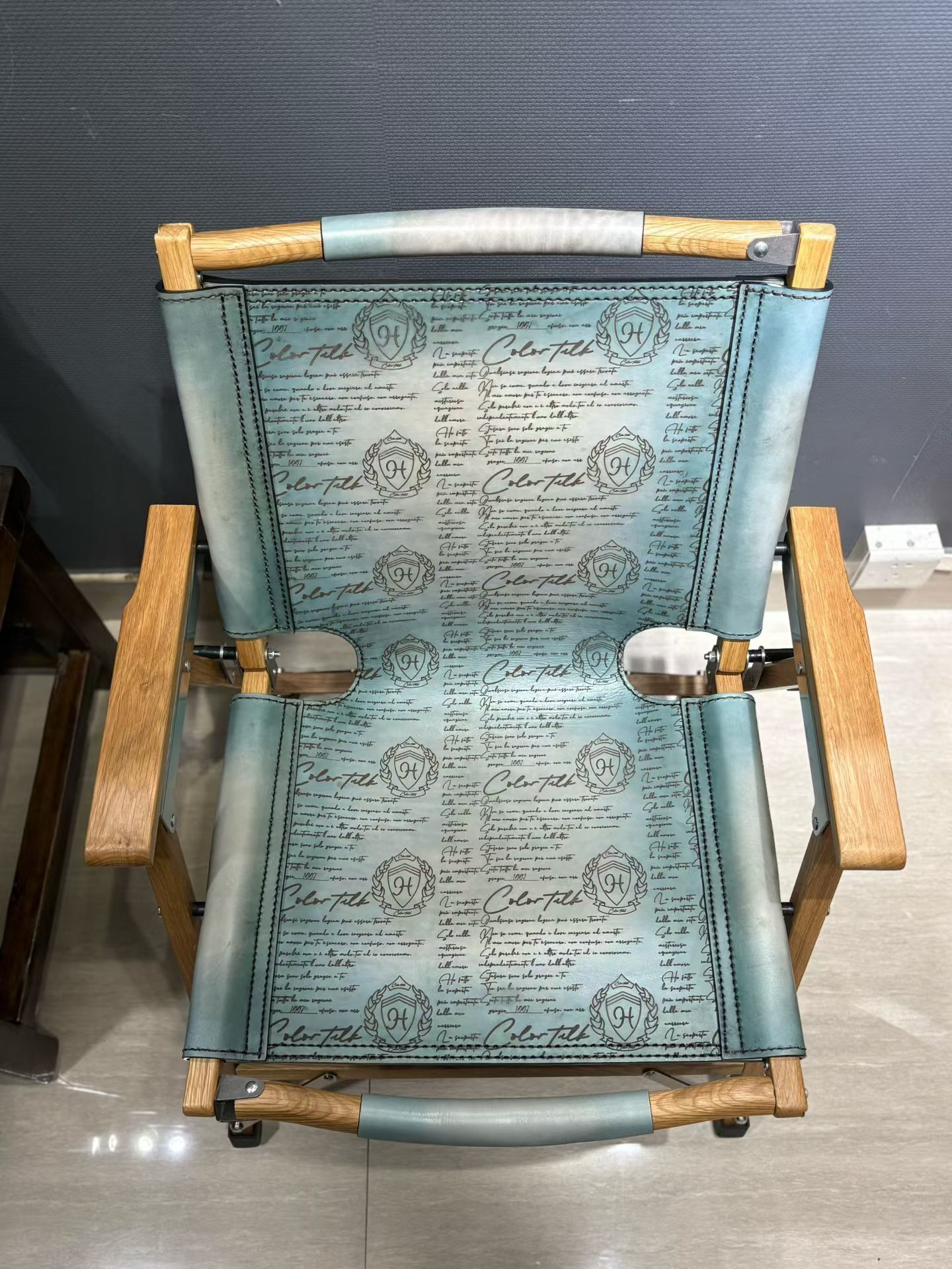 Berluti Metro wooden folding chair with a brown leather seat and backrest.